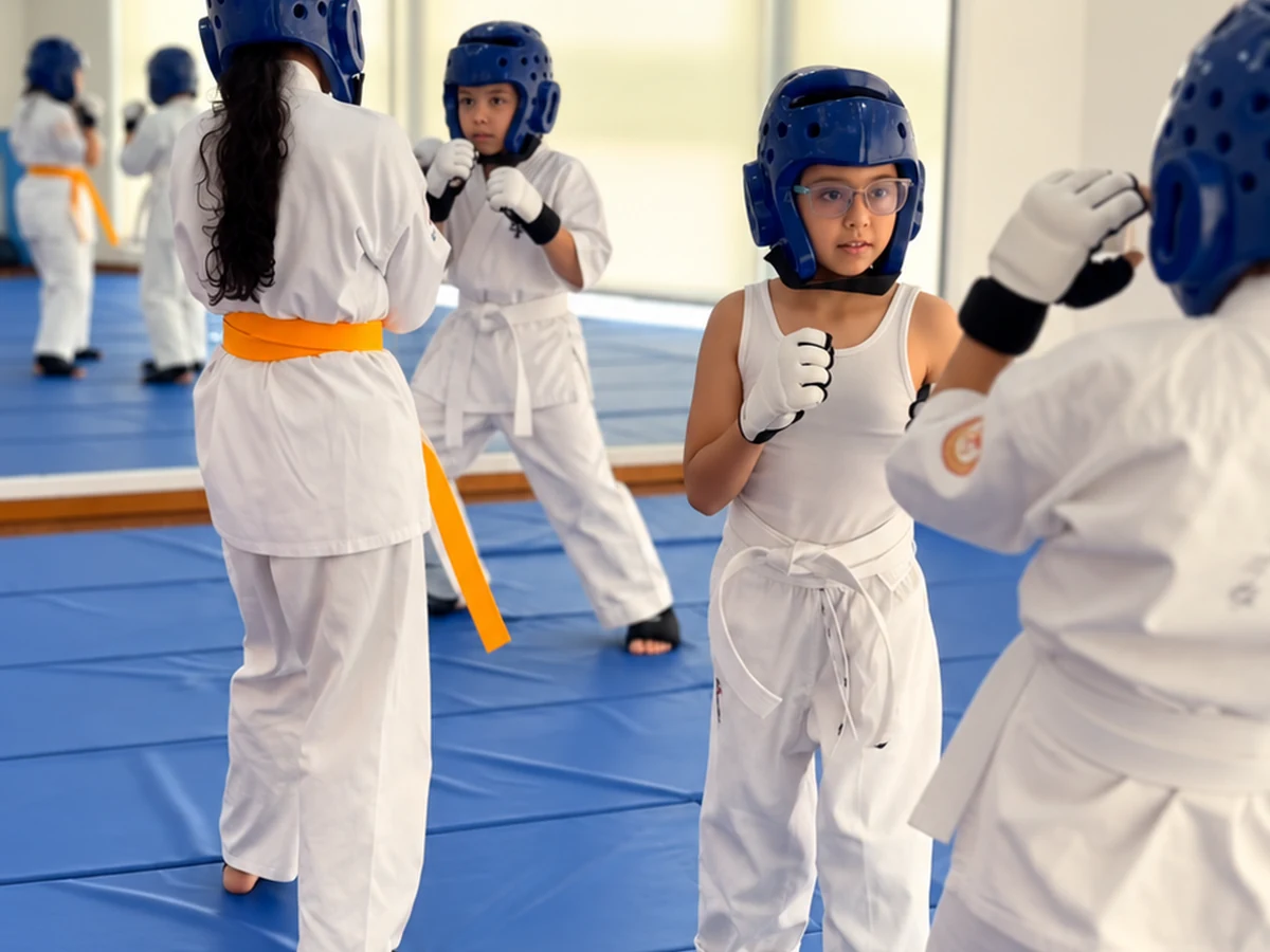 Niños de 6 a 11 años practicando karate con protección