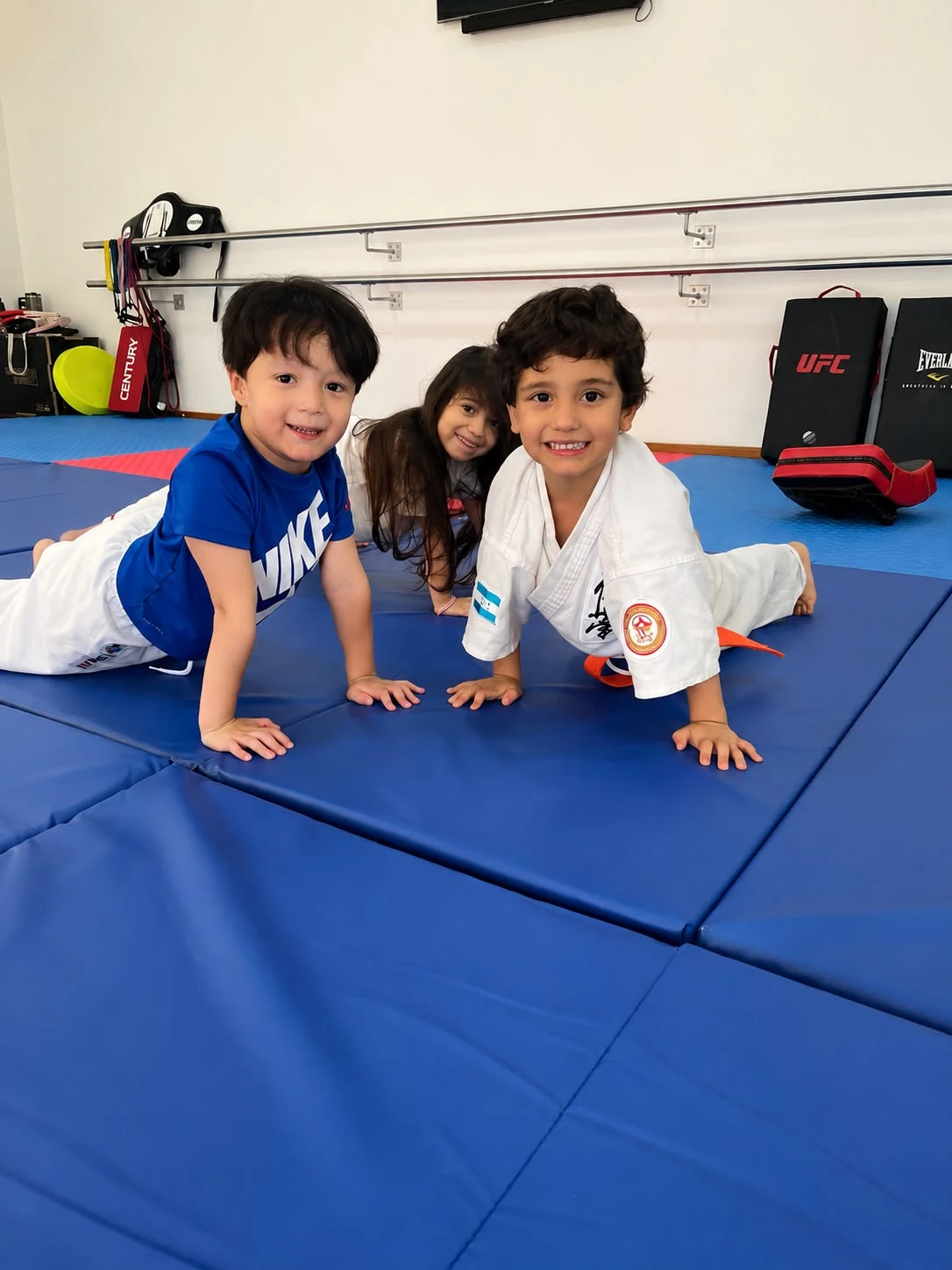 Niños compartiendo un momento en el tatami de Okami Dojo
